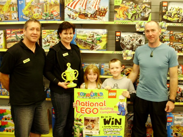 Toyworld Whangarei owners Steve and Julie present Issac with his Championship trophy, Issac's father Bryce and sister Grace share the proud moment
